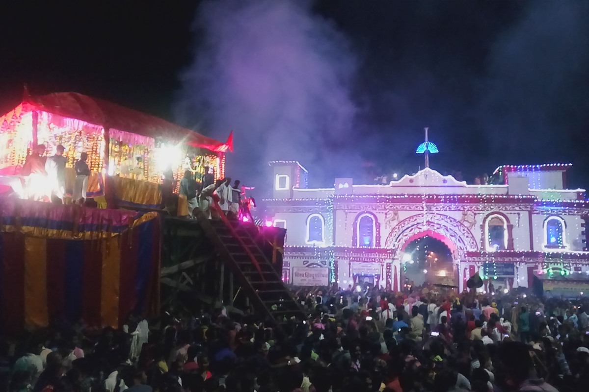 A decorated wooden chariot and a crowd outside an illuminated building during Bastar Dussehra in Jagdalpur, photographed in 2017.
