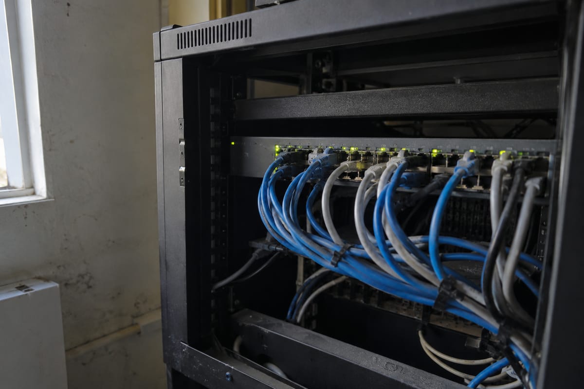 AI-generated illustration of network cables and a switch inside an office equipment cabinet.
