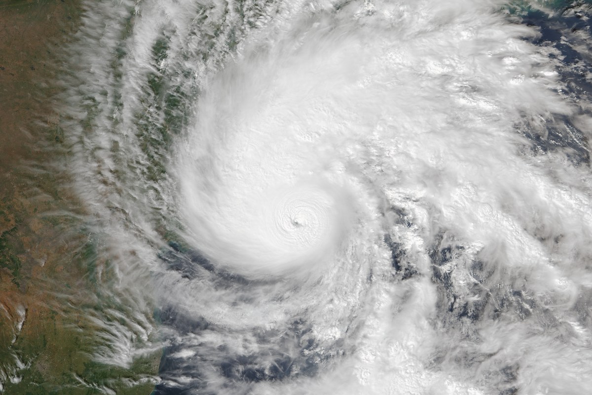 Satellite image of Cyclone Arnab, a large swirl of white cloud with a small eye at its centre, over the Bay of Bengal beside the green-brown Indian coast.