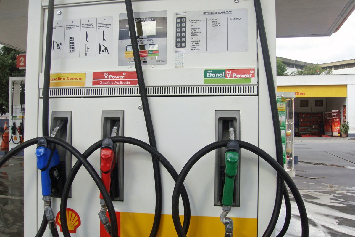 A fuel dispenser at a petrol station with blue, red and green nozzles; the green nozzle on the right is labelled for ethanol.
