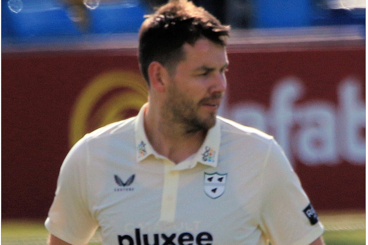 New Zealand fast bowler Jacob Duffy in a cream Worcestershire cricket shirt, looking to his left on the field.