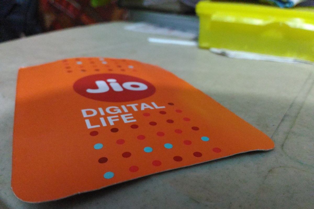 An orange Jio SIM card holder with the Jio logo and the words ‘Digital Life’, lying on a table.