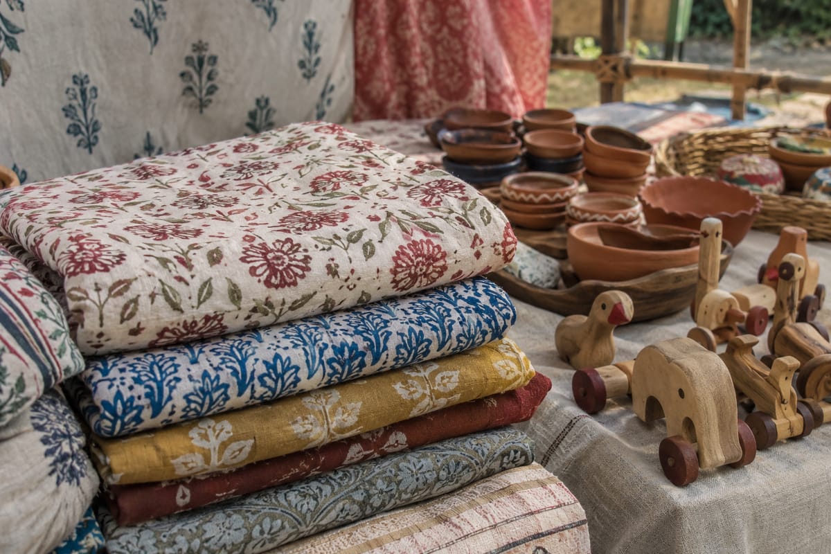AI-generated illustration of textiles, terracotta bowls and wooden toys at a craft stall.