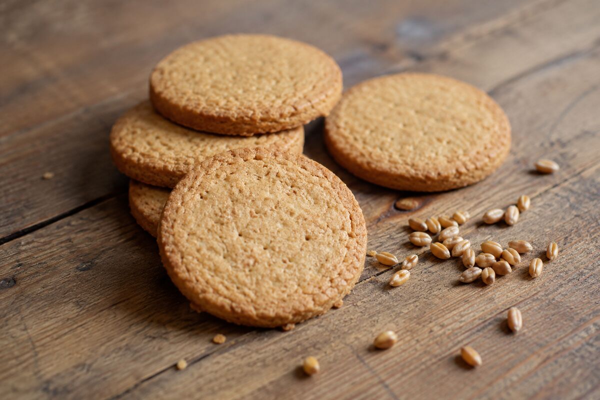 AI-generated representational image of plain unbranded biscuits and wheat grains on a wooden table