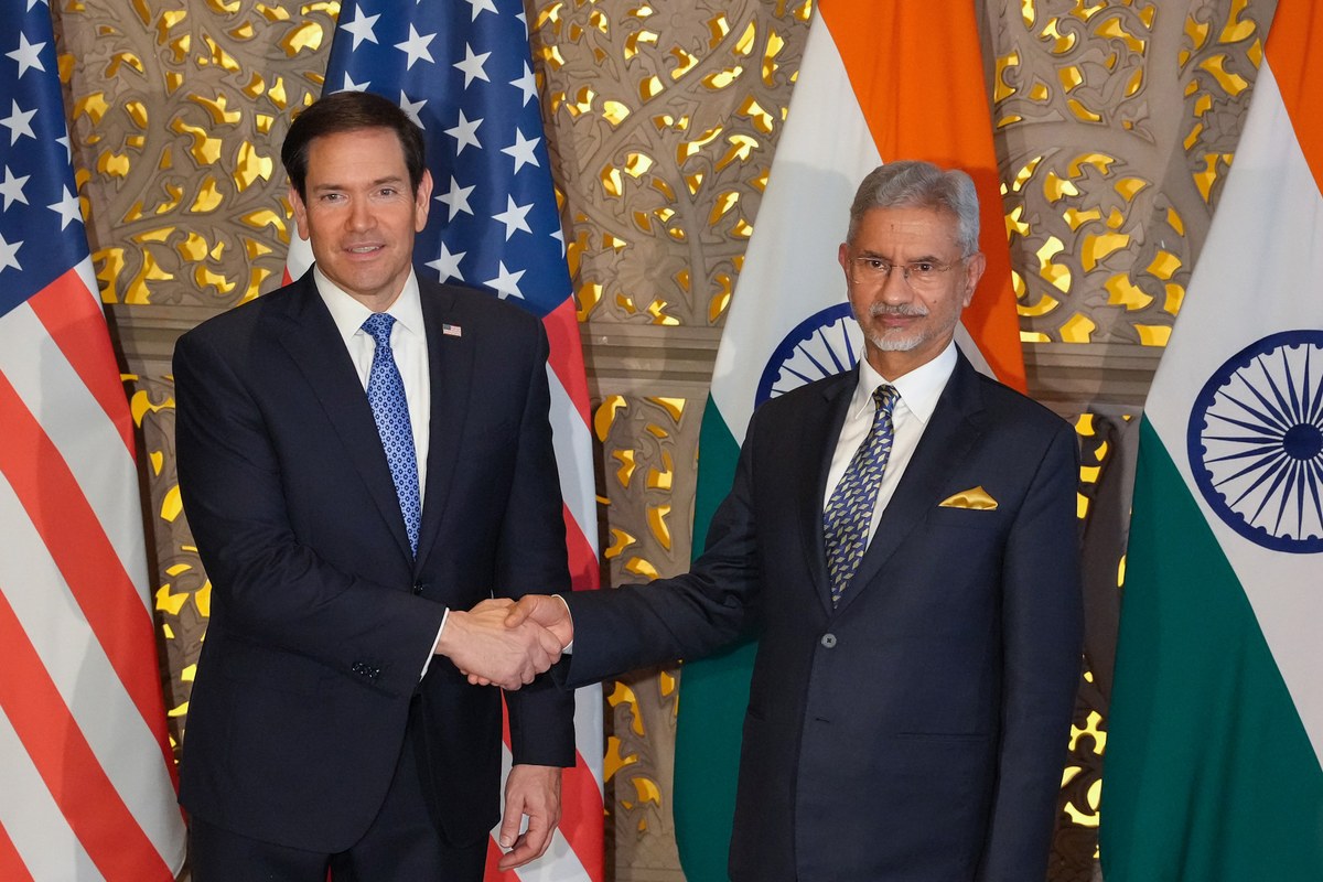 US Secretary of State Marco Rubio and External Affairs Minister S Jaishankar shake hands in front of US and Indian flags in Mumbai.