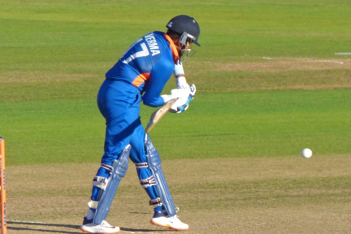 Shafali Verma in India's blue kit and helmet, number 17 on her back, waits to play a ball while batting on a green outfield.