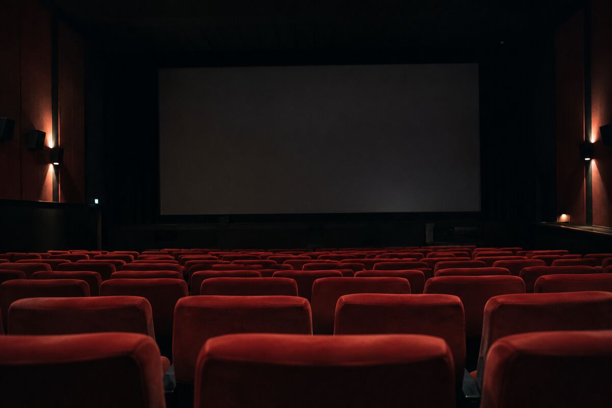 AI-generated representational image of an empty cinema with red seats and a blank screen